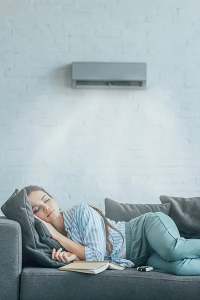 Woman Sleeping Couch Book Air Conditioner Blowing Her — стоковое фото