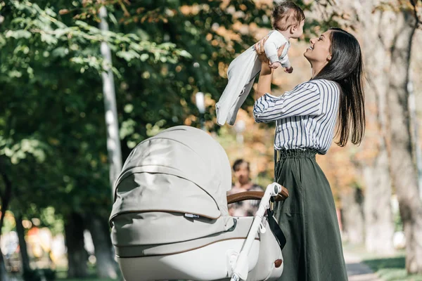 Happy Mother Holding Baby Stroller Park — стоковое фото