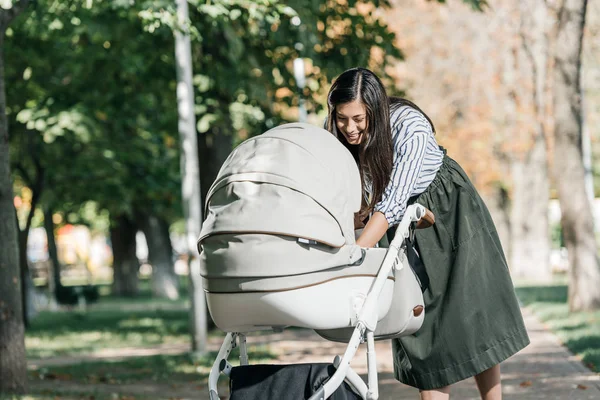 Attractive Happy Mother Looking Baby Stroller Park — стоковое фото