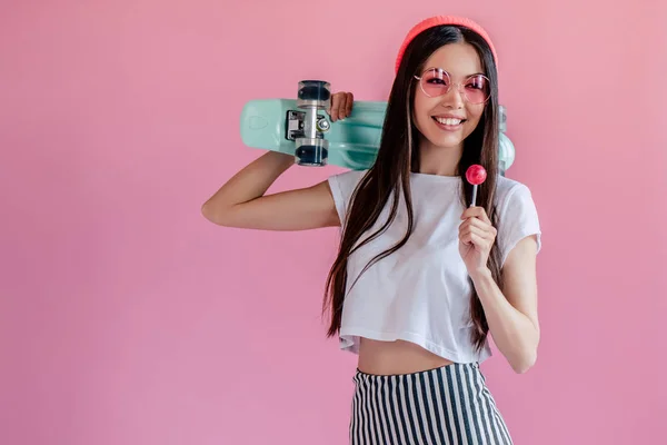 Young Asian Teenage Girl Pink Background Stylish Girl Lollipop Skateboard — стоковое фото
