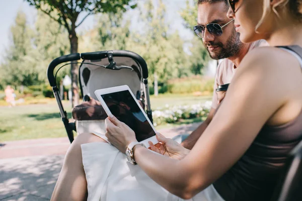 Mother Father Sitting Baby Carriage Park Looking Tablet Blank Screen — стоковое фото