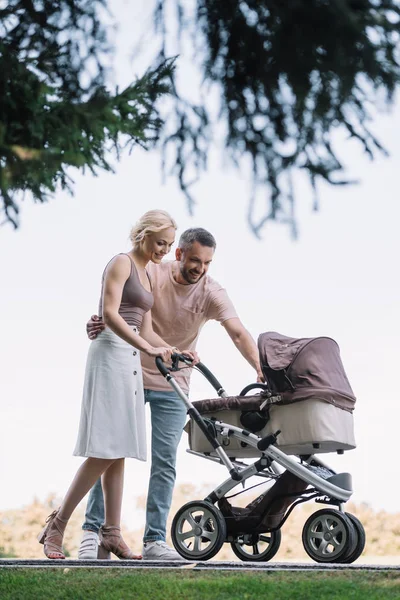 Happy Parents Walking Baby Carriage Looking Baby Park — стоковое фото