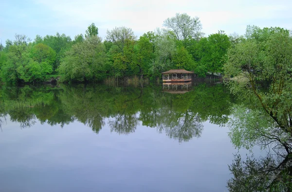 Простая деревянная беседка на берегу озера — стоковое фото