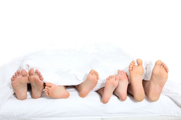 Крупным планом семьи футов в постели — стоковое фото