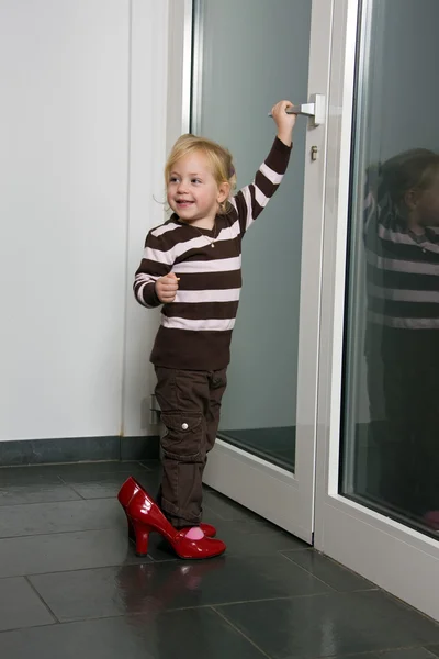Ребенок с большие ботинки открывает двери — стоковое фото