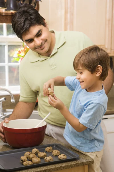 Папа и сын, делая печенье — стоковое фото