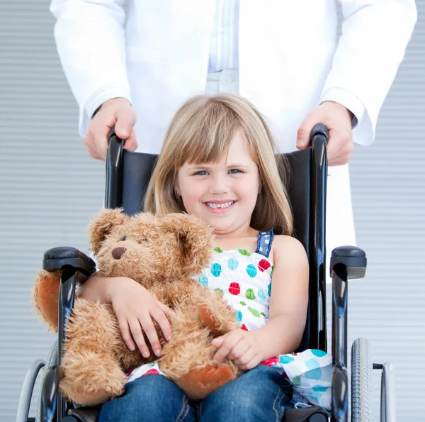 Портрет маленькая девочка сидит на инвалидной коляске, поддерживаемых — стоковое фото